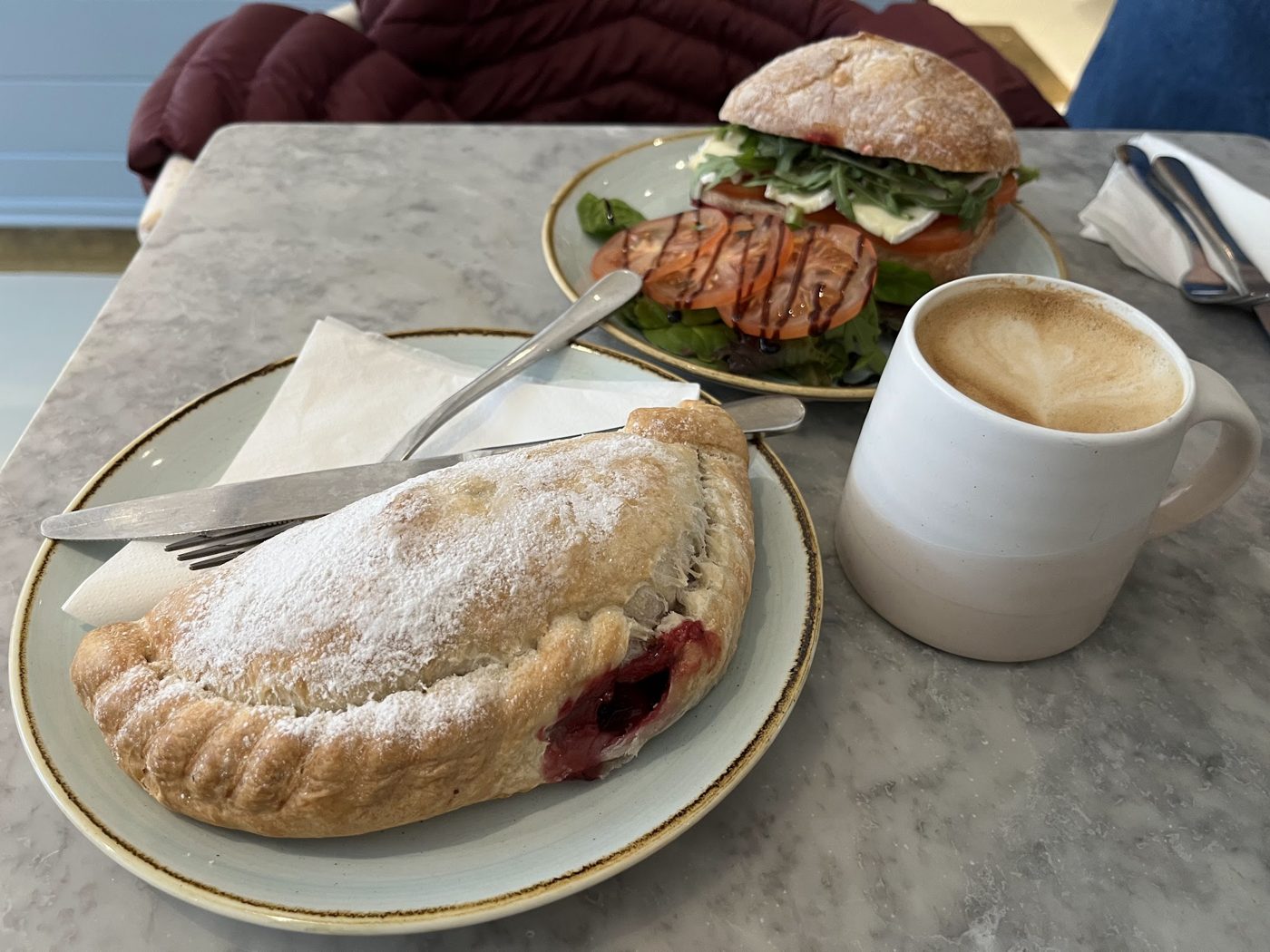 A pasty with a sandwich and a coffee